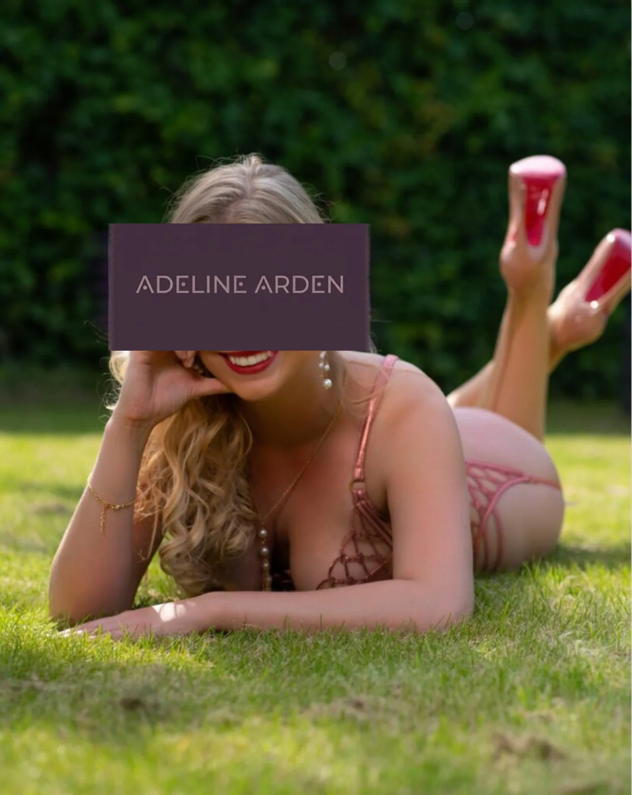 Adeline reclining outdoors in rose-coloured lingerie
